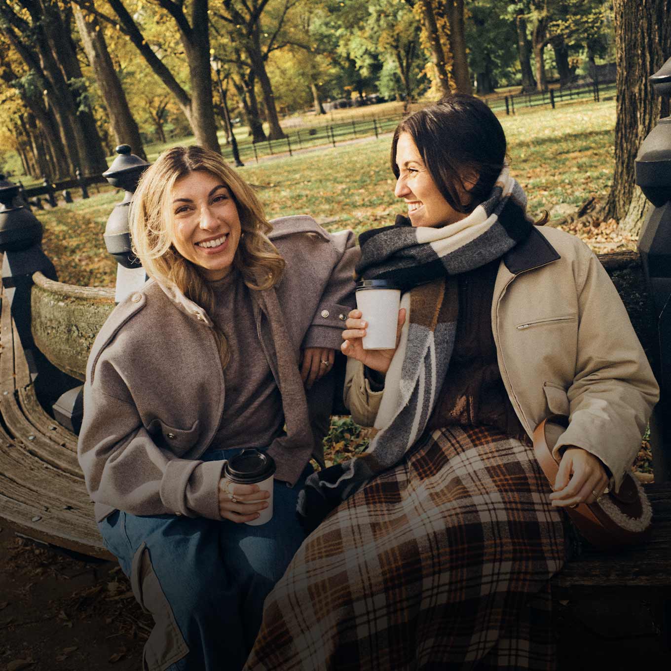 two girls drinking coffee in fall outfits