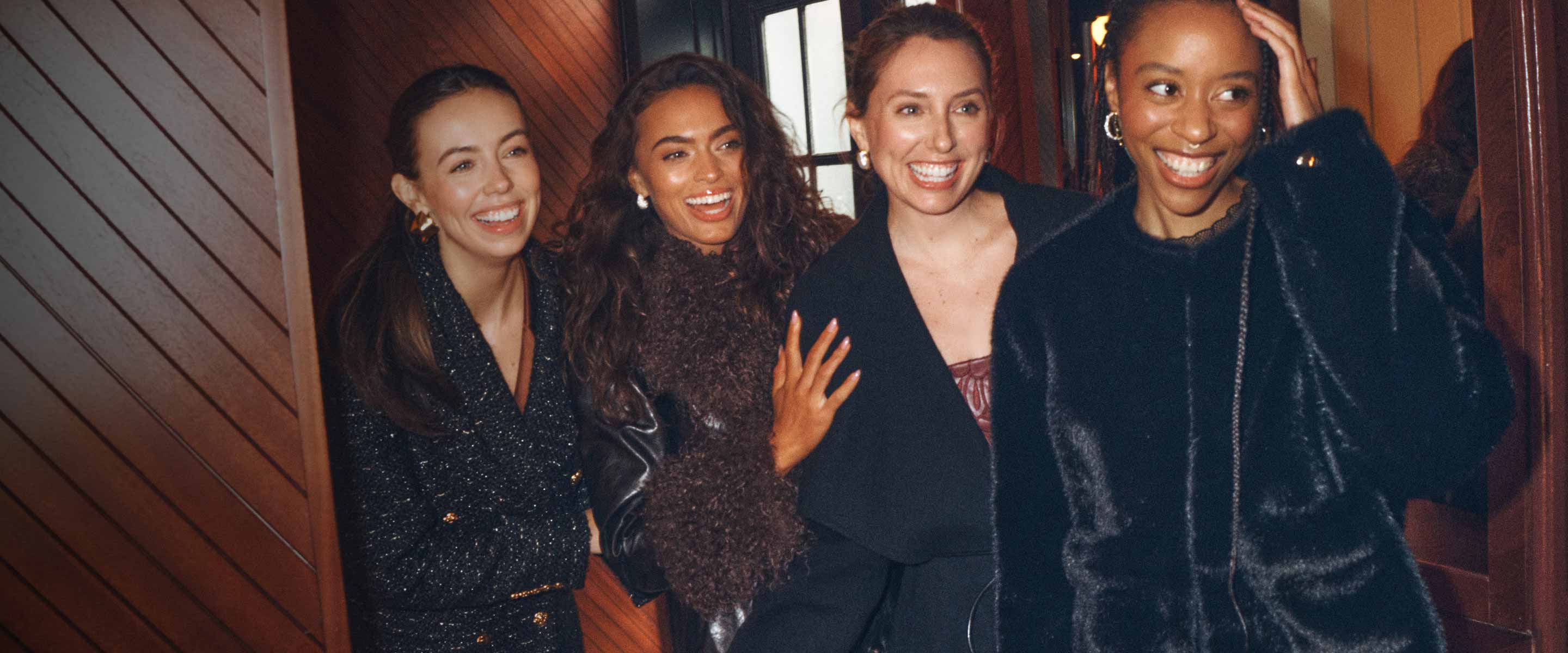 four girls in coats smiling